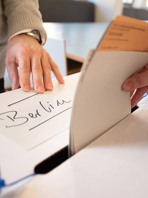 Eine Frau gibt in einem Wahllokal Wahlzettel für die Wahl des Berliner Abgeordnetenhauses und den Volksentscheid für die Vergesellschaftung von Immobilienbeständen ab. 