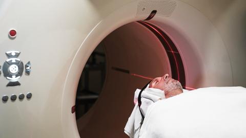 Eine Person wird in eine PET-Scan Maschine in einem Krankenhaus geschoben.