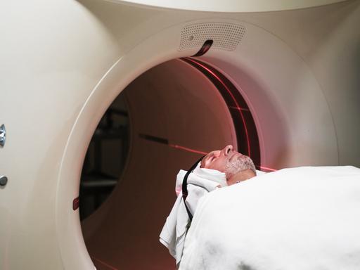 Eine Person wird in eine PET-Scan Maschine in einem Krankenhaus geschoben. Eine Person wird in eine PET-Scan Maschine in einem Krankenhaus geschoben.