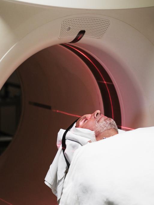 Eine Person wird in eine PET-Scan Maschine in einem Krankenhaus geschoben. Eine Person wird in eine PET-Scan Maschine in einem Krankenhaus geschoben.