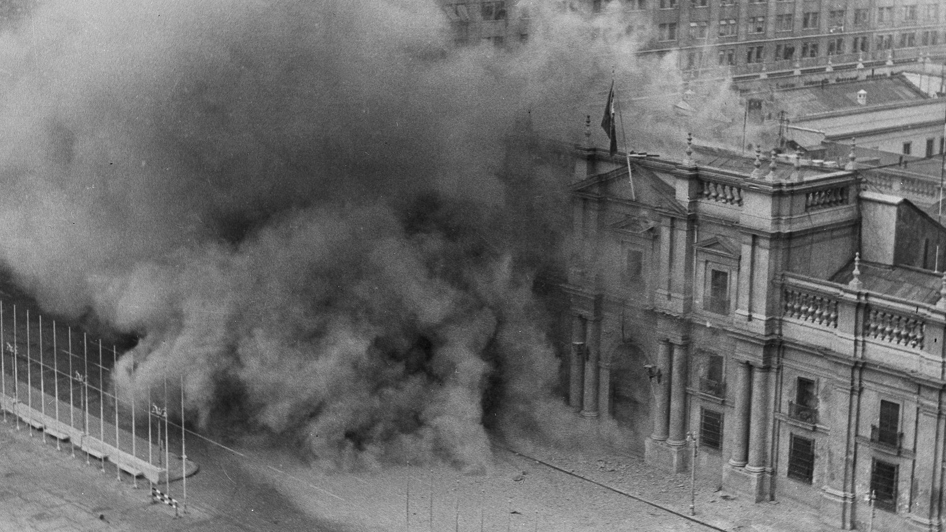 Historisches Schwarzweißfoto vom Präsidentenpalast in Santiago de Chile, aus dem Rauch aufsteigt.