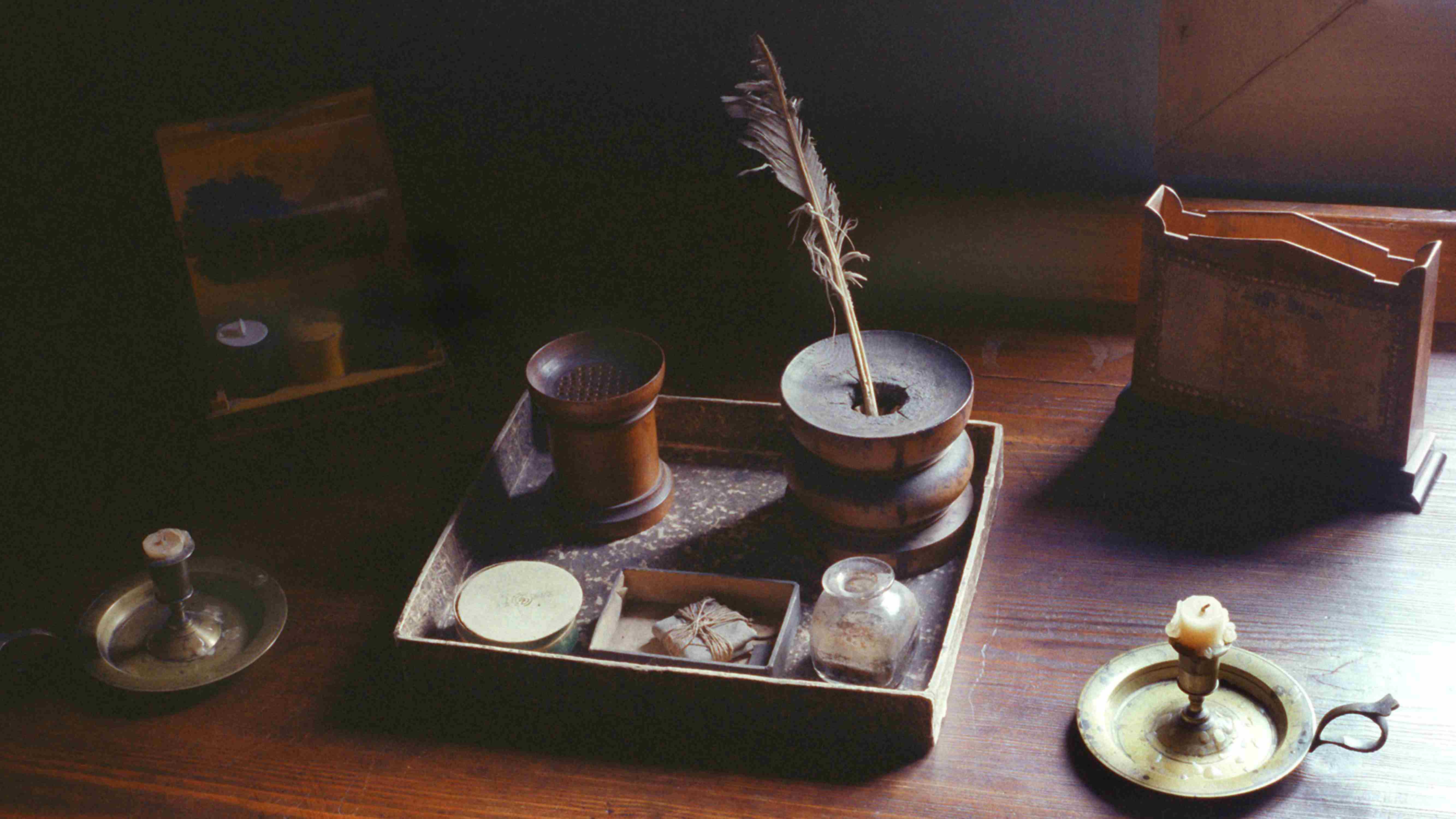 Ein historischer Schreibtisch mit Feder und Tintenfass