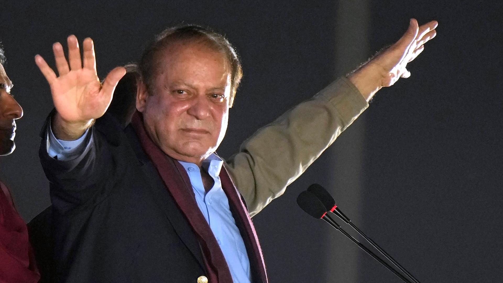 Pakistan's ehemaliger Premierminister Nawaz Sharif reckt bei einer Versammlung vor seinen Unterstützern beide Arme in die Höhe.
