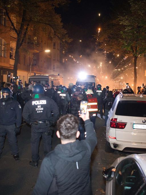 Es ist zu sehen, wie Teilnehmer einer verbotenen Pro-Palästina-Demonstration in der Nähe der Sonnenallee im Bezirk Neukölln Pyrotechnik zünden.