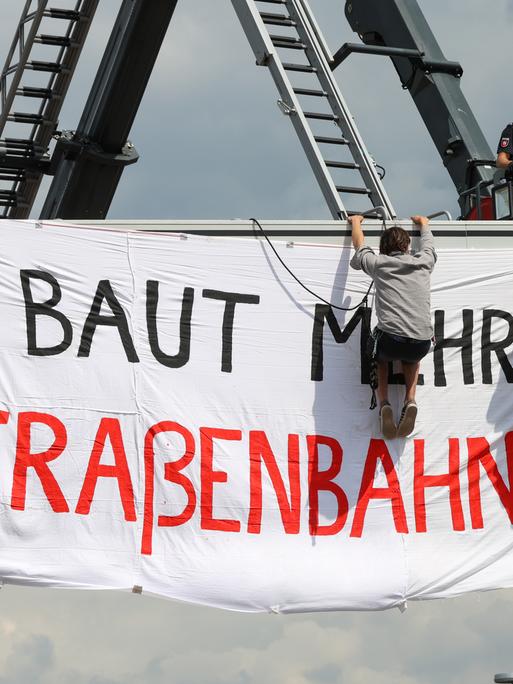 Polizei und Aktivisten an einer Schilderbrücke an der VW-Lieferzufahrt. Dort wurde ein Transparent mit der Aufschrift "Baut mehr Straßenbahnen" aufgehangen. Aktivisten verschiedener Klimaschutzgruppen hatten die Hauptzufahrt zum Volkswagenwerk blockiert.