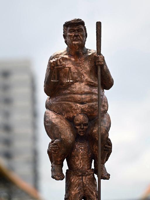 Hier sehen Sie die Kopie der Skulptur „Survival of the Fattest“ des dänischen Künstlers Jens Galschiot, die den Titel „King of Injustice“ trägt. Die Skulptur ist ein satirischer Protest gegen US-Präsident Donald Trump.