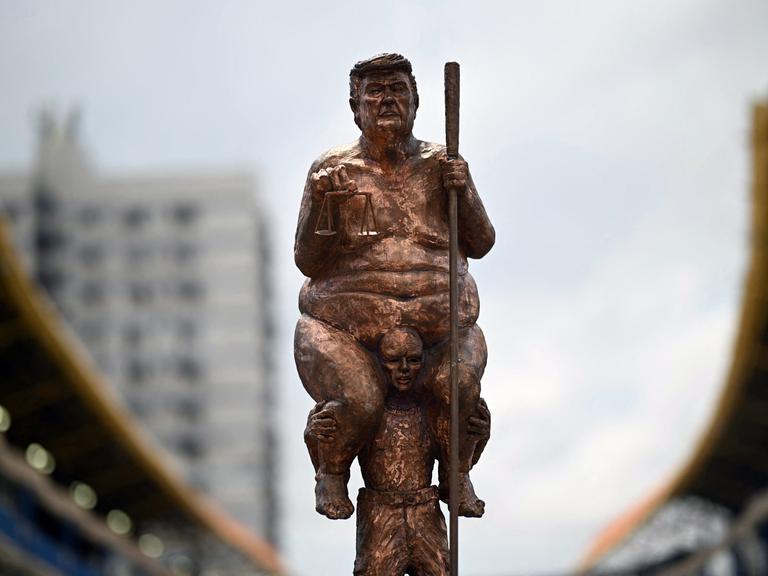 Hier sehen Sie die Kopie der Skulptur „Survival of the Fattest“ des dänischen Künstlers Jens Galschiot, die den Titel „King of Injustice“ trägt. Die Skulptur ist ein satirischer Protest gegen US-Präsident Donald Trump.