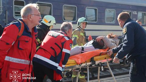 Rettungssanitäter transportieren einen Verletzten auf einer Bahre.