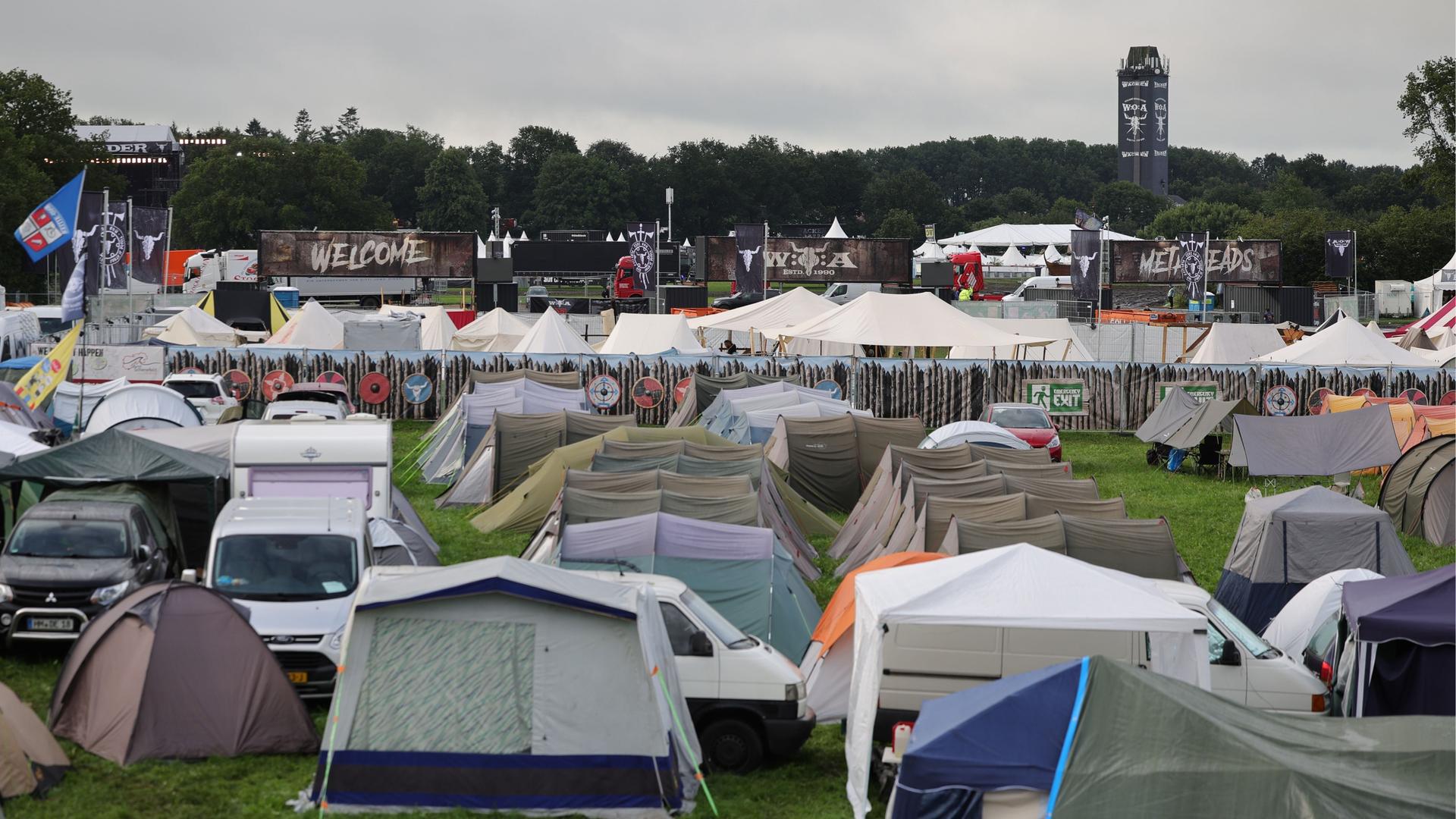 Schleswig-Holstein, Wacken: Blick über Zeltplätze nahe der Hauptbühnen auf dem vom Regen aufgeweichten und schlammigen Festivalgelände.