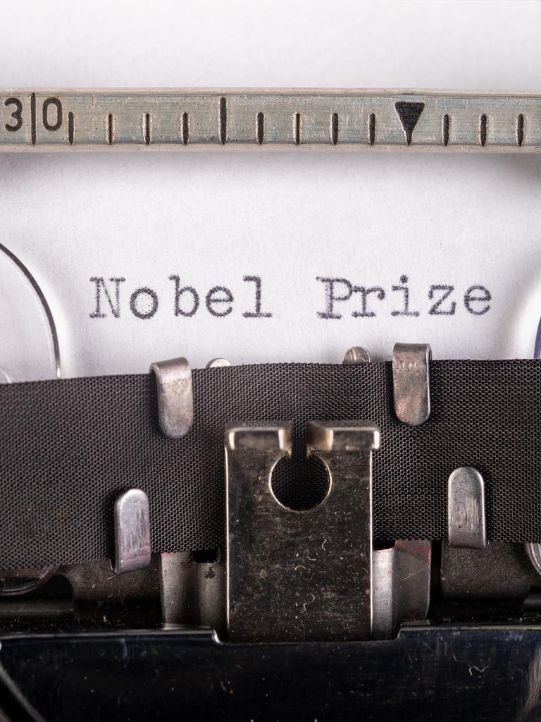 Die Worte Nobel und Prize, getippt auf ein Blatt Papier, das in eine Schreibmaschine eingespannt ist.