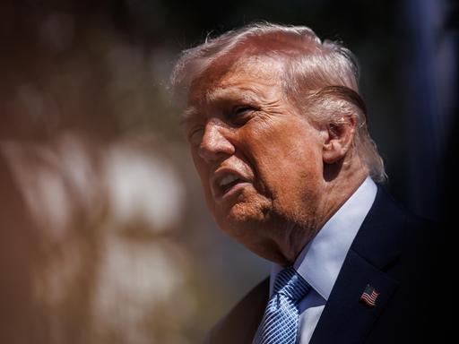 Präsident Trump hält vor unscharfem Bildhintergrund eine Ansprache und wirkt agitiert Präsident Trump hält vor unscharfem Bildhintergrund eine Ansprache und wirkt agitiert