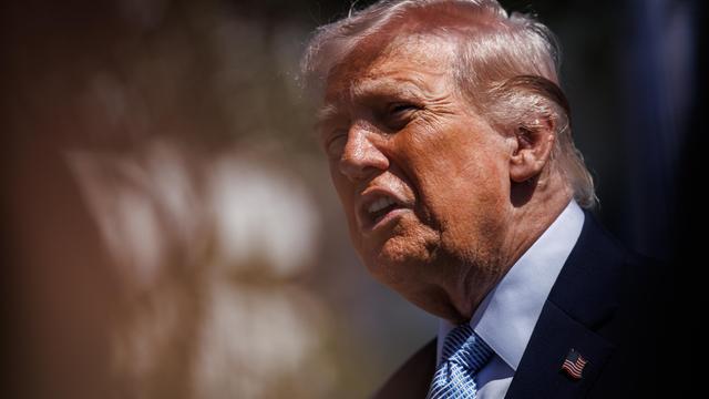 Präsident Trump hält vor unscharfem Bildhintergrund eine Ansprache und wirkt agitiert