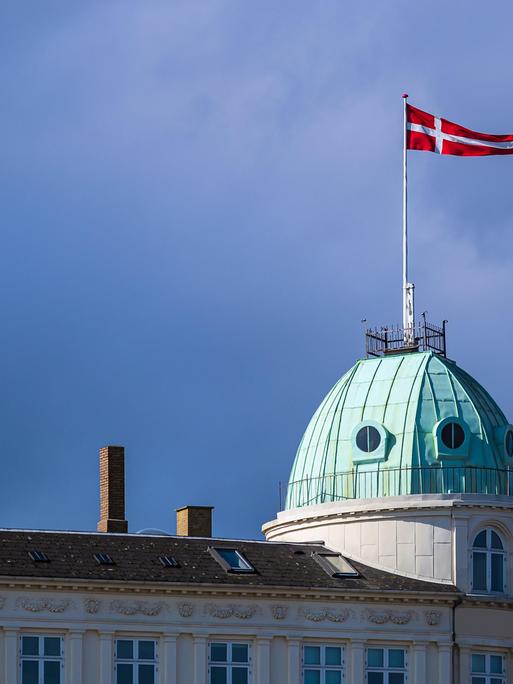 Die dänische Nationalflagge weht auf einem Gebäude.
