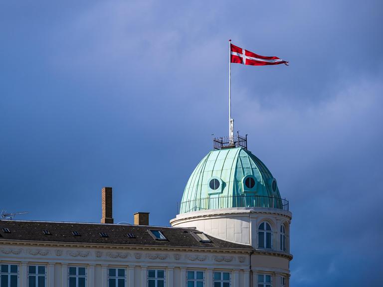 Die dänische Nationalflagge weht auf einem Gebäude.