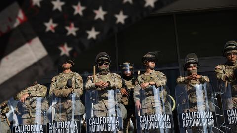 Soldaten der Nationalgarde sind während Protesten als Reaktion auf eine Reihe von Razzien der Einwanderungs- und Zollbehörde der Vereinigten Staaten (ICE) im ganzen Land in der Nähe eines Eingangs zu einem Bundesgebäude in Los Angeles postiert.