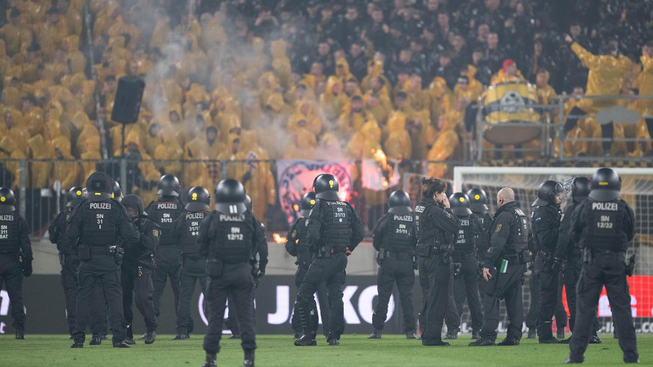 2. Bundesliga, Dynamo Dresden - Hertha BSC: Polizisten stehen während einer Spielunterbrechung im Stadion auf dem Spielfeld vor dem K-Block mit den Fans von Dynamo Dresden.