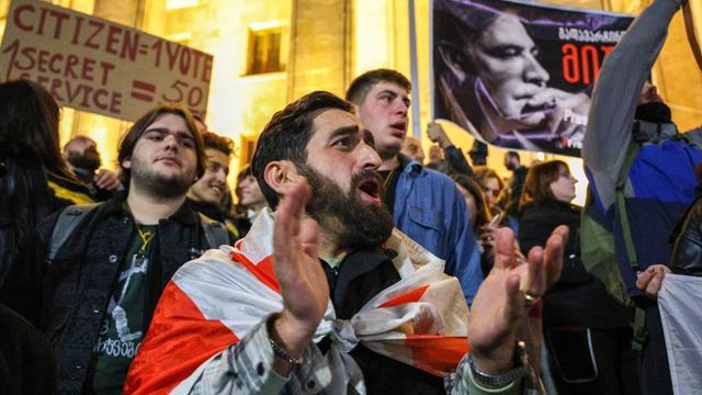 Menschen protestieren vor dem Parlementsgebäude in Tiflis.