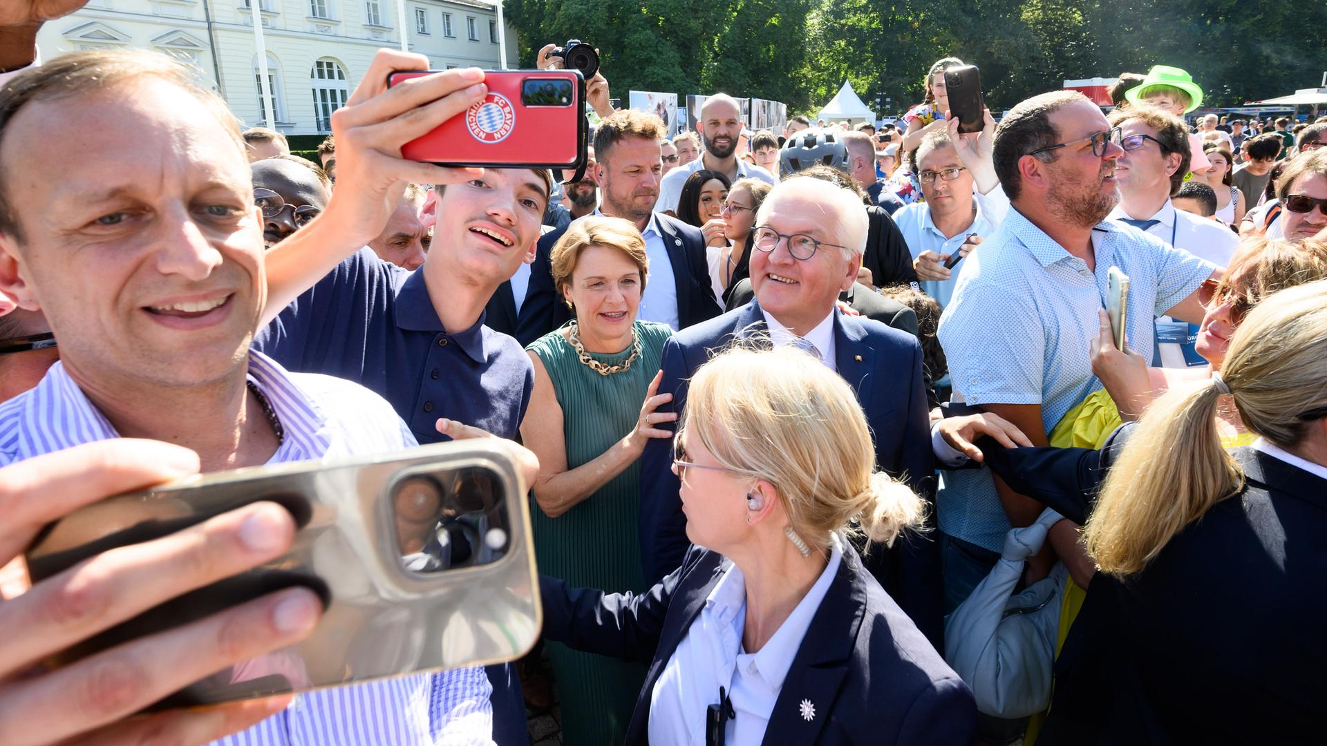 Bundespräsident Frank-Walter Steinmeier und seine Frau Elke Büdenbender bahnen sich nach ihre Ankunft beim Tag des offenen Schlosses von Bundespräsident Steinmeier im Park von Schloss Bellevue ihren Weg.