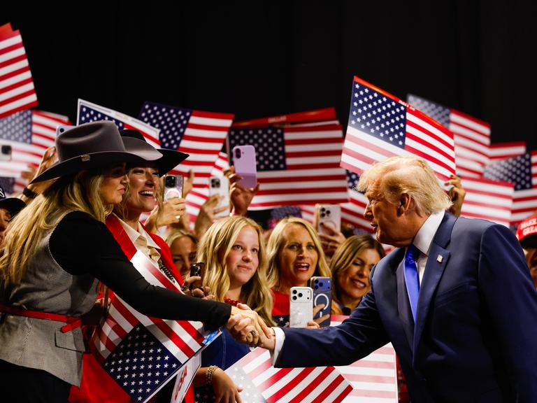 US-Präsident Donald Trump begrüßt blonde Frauen in Cowboyhüten, als er am 9. September 2026 in Dallas, Texas, auf die Bühne geht, um am ersten Tag des Republikanischen Parteitags 2026 eine Rede zu halten. US-Präsident Donald Trump begrüßt blonde Frauen in Cowboyhüten, als er am 9. September 2026 in Dallas, Texas, auf die Bühne geht, um am ersten Tag des Republikanischen Parteitags 2026 eine Rede zu halten.