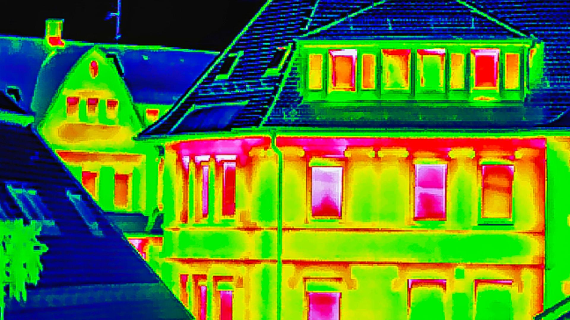 Wärmebild eines Wohngebäudes (Thermografie), die Fenster leuchten in einem warmen Rotton 