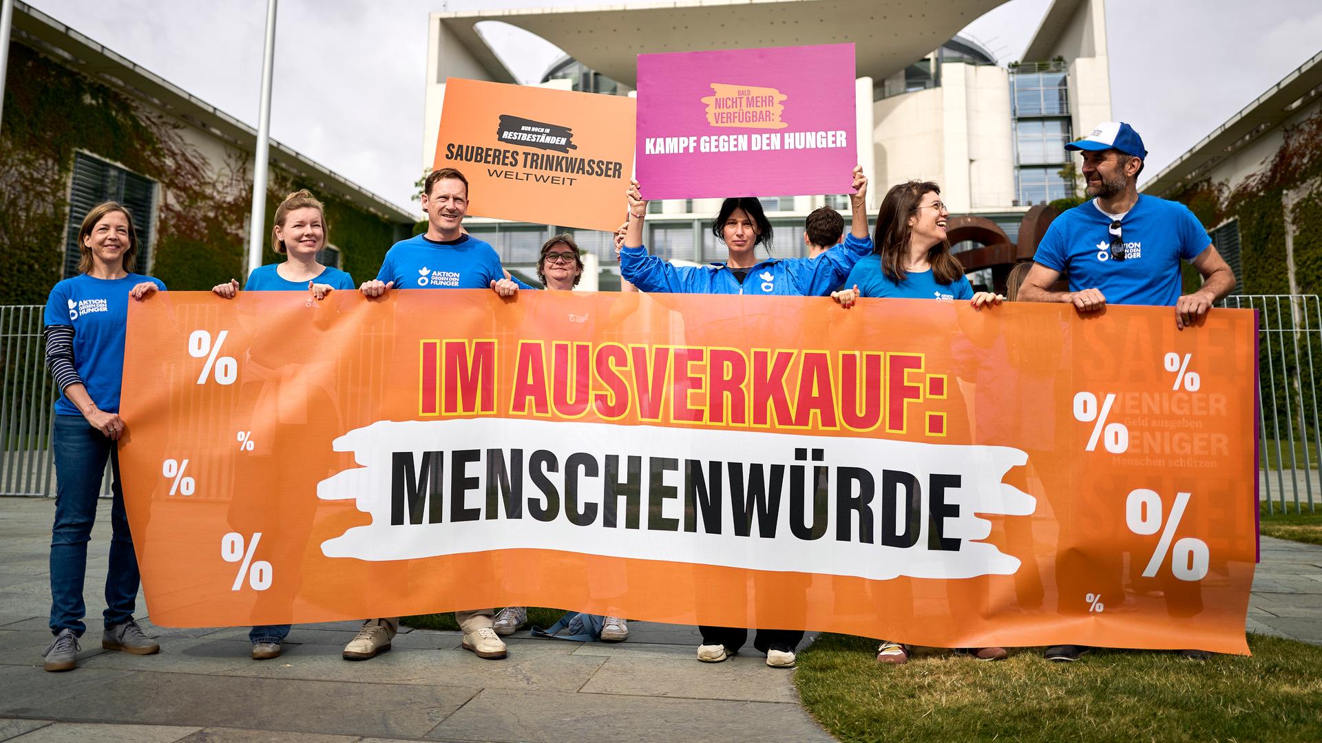 Demonstrierende stehen mit Transparenten, unter anderem mit dem Aufdruck "Im Ausverkauf: Menschenwürde", und Schildern vor dem Bundeskanzleramt. Demonstrierende stehen mit Transparenten, unter anderem mit dem Aufdruck "Im Ausverkauf: Menschenwürde", und Schildern vor dem Bundeskanzleramt.