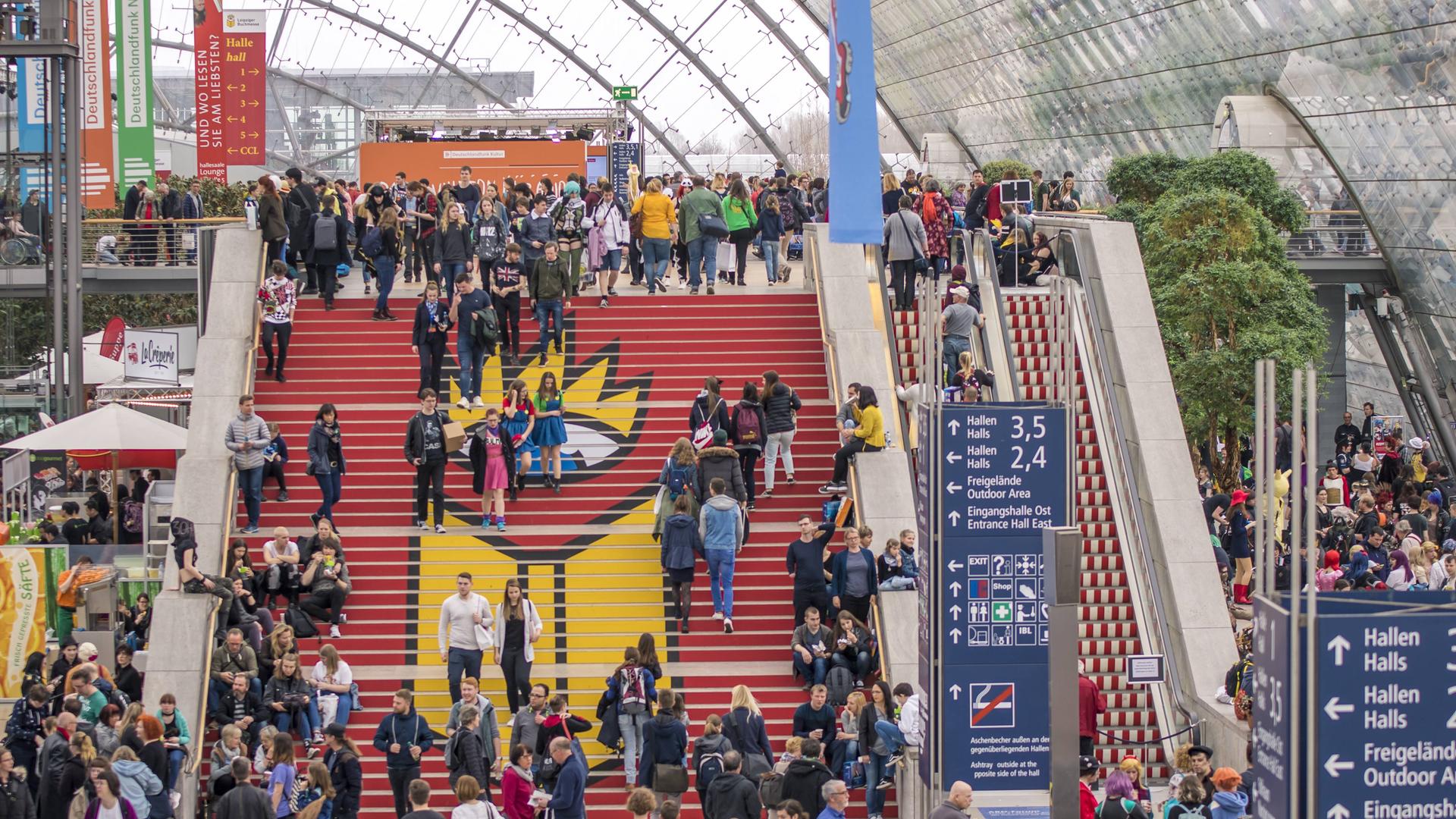 Menschen gehen bei der Leipziger Buchmesse 2019 eine Treppe hoch.