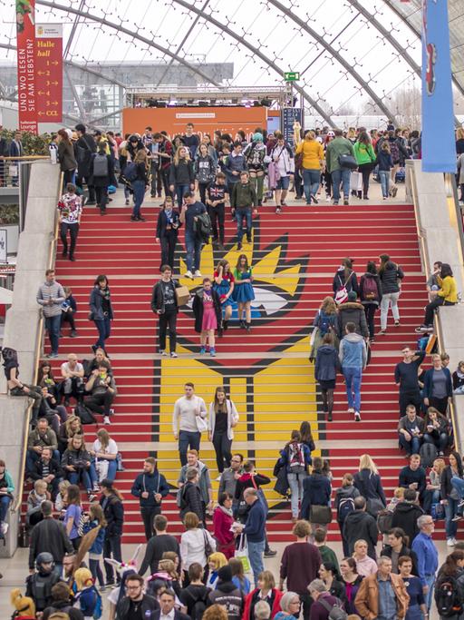 Menschen gehen bei der Leipziger Buchmesse 2019 eine Treppe hoch.