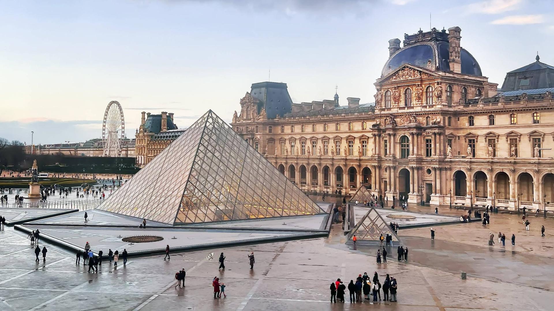 Aussenaufnehme des Louvre in Paris vor blauem wolkigem Himmel Aussenaufnehme des Louvre in Paris vor blauem wolkigem Himmel