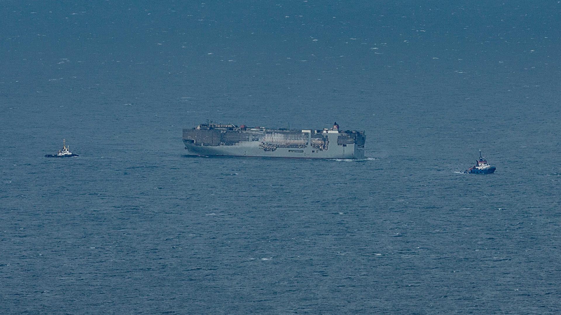 Luftaufnahme des brennenden Frachters Fremantle Highway, der zu einem provisorischen Ankerplatz nördlich von Ameland und Schiermonnikoog geschleppt wird. Luftaufnahme des brennenden Frachters Fremantle Highway, der zu einem provisorischen Ankerplatz nördlich von Ameland und Schiermonnikoog geschleppt wird.