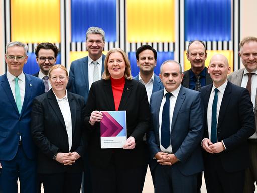 Bärbel Bas (SPD), Bundesministerin für Arbeit und Soziales, steht während der Übergabe des Berichts der Kommission zur Sozialstaatsreform mit den Kommissionsmitgliedern im Arbeitsministerium.