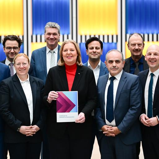 Bärbel Bas (SPD), Bundesministerin für Arbeit und Soziales, steht während der Übergabe des Berichts der Kommission zur Sozialstaatsreform mit den Kommissionsmitgliedern im Arbeitsministerium.