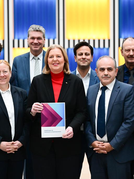 Bärbel Bas (SPD), Bundesministerin für Arbeit und Soziales, steht während der Übergabe des Berichts der Kommission zur Sozialstaatsreform mit den Kommissionsmitgliedern im Arbeitsministerium.