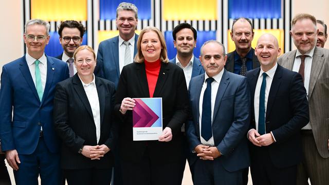 Bärbel Bas (SPD), Bundesministerin für Arbeit und Soziales, steht während der Übergabe des Berichts der Kommission zur Sozialstaatsreform mit den Kommissionsmitgliedern im Arbeitsministerium.