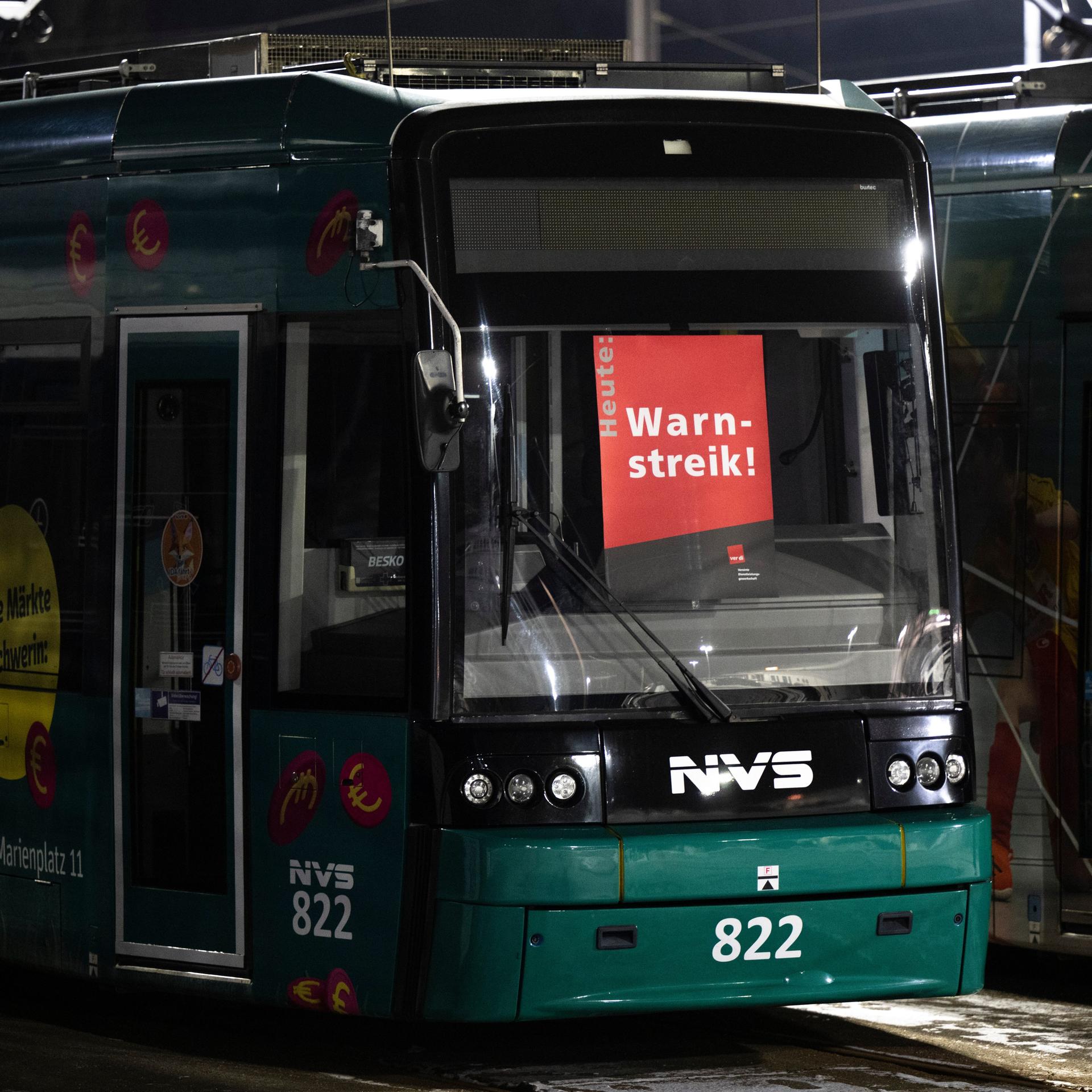 An der Frontscheibe einer Straßenbahn hängt ein Plakat mit der Aufschrift "Warnstreik".