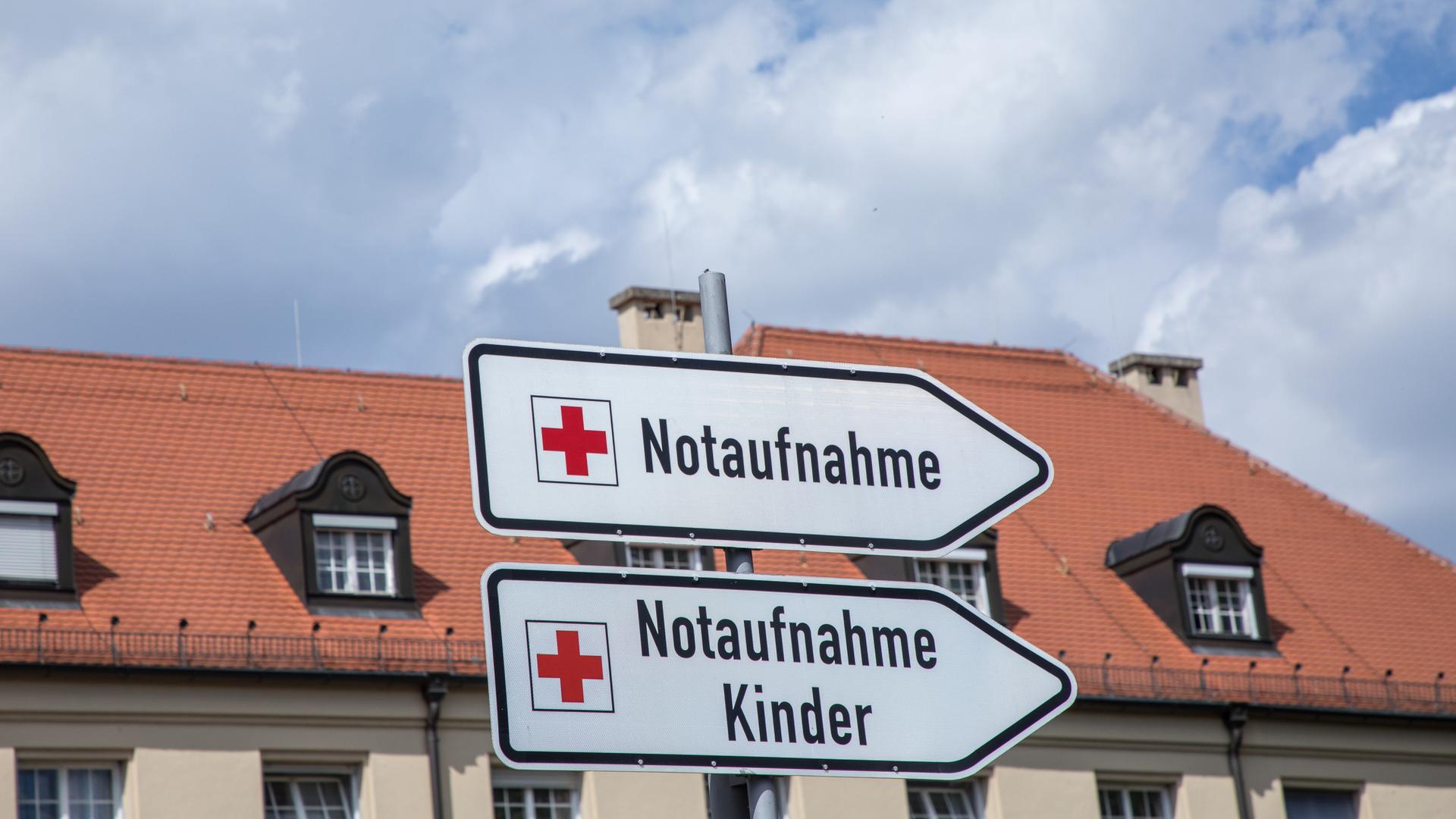 Blick auf die Klinik Schwabing in München mit Hinweistafeln zur Notaufnahme und Notaufnahme für Kinder.