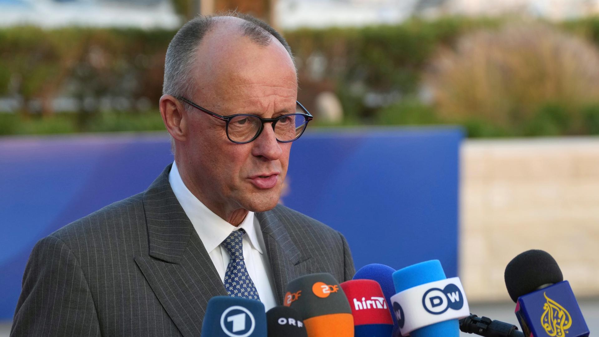 Bundeskanzler Friedrich Merz (CDU) steht hinter mehreren Mikrofonen von Radio- und Fernsehsendern. 