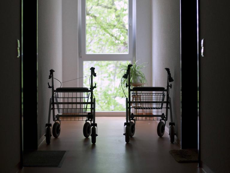 Zwei Rollatoren stehen in einem Hausflur vor einem Fenster.