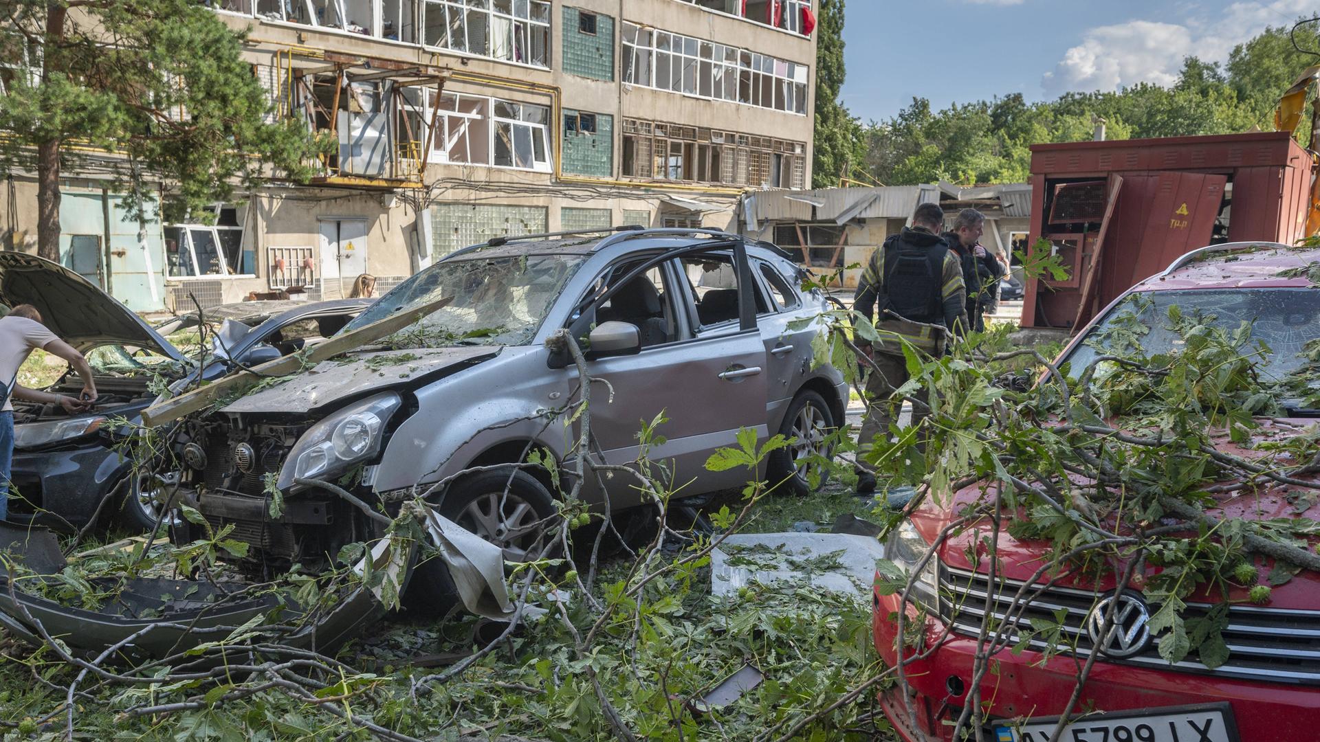 Zerstörungen in einem Industriegebiet in Charkiw (Ukraine) nach einem russischen Angriff. Auch in der Nähe der Einschlagstelle geparkte Fahrzeuge wurden beschädigt. 