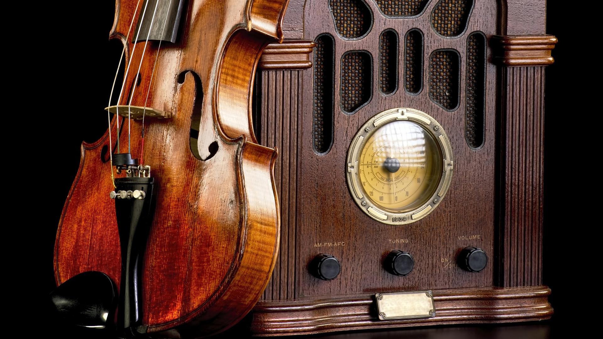 An einem historischen Radio lehnt eine Violine.