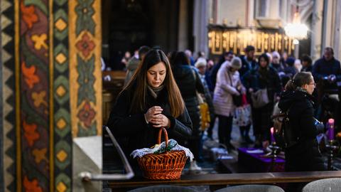 Eine Frau während der Segnung mit ihrem Osterkorb in einer Kirche der ukrainischen Stadt Lwiw.