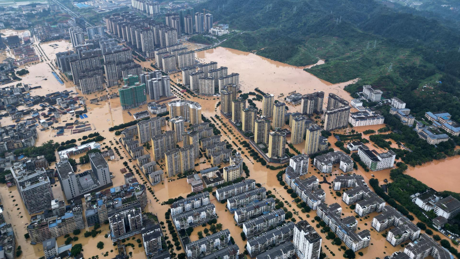 Man sieht viele Hochhäuser in der Stadt Rongjiang in der Provinz Guizhou, dazwischen sind die Straßen komplett überflutet. Man sieht viele Hochhäuser in der Stadt Rongjiang in der Provinz Guizhou, dazwischen sind die Straßen komplett überflutet.