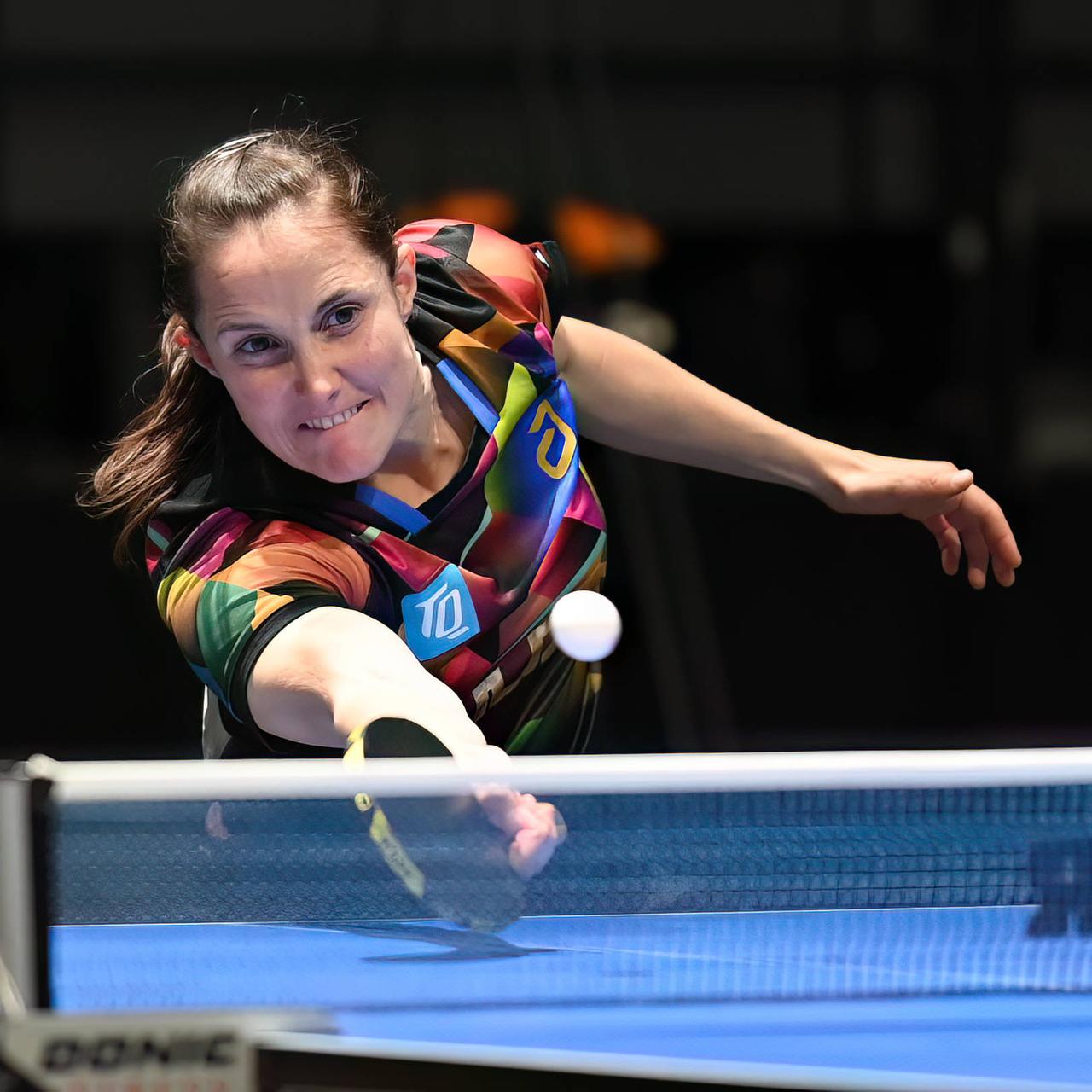 Das Bild zeigt Sabine Winter an einer Tischtennis-Platte. Sie retourniert den Ball mit einem Schläger und angestrengtem Gesichtsausdruck.