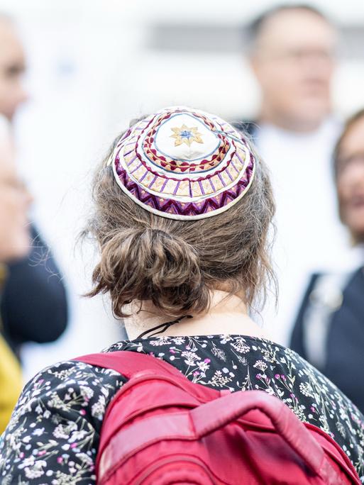 Eine Frau mit Kippa, die den Sommerempfang der jüdischen Gemeinde in der Neuen Synagoge Berlin besucht, ist von hinten zu sehen.