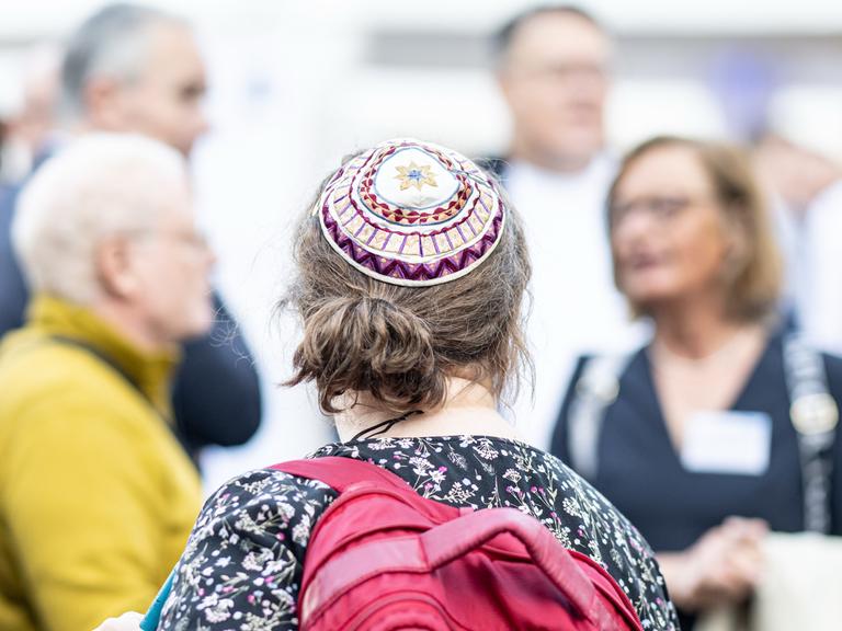 Eine Frau mit Kippa, die den Sommerempfang der jüdischen Gemeinde in der Neuen Synagoge Berlin besucht, ist von hinten zu sehen.