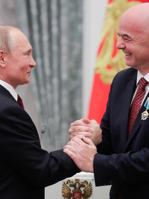 Putin und Infantino geben sich herzlich die Hände.
