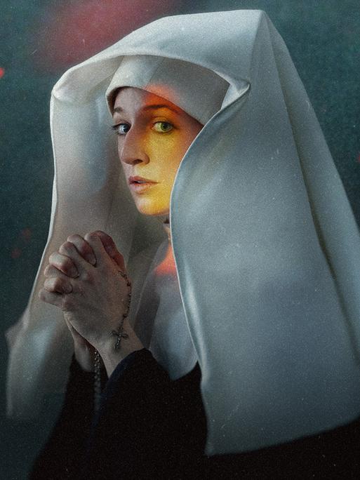 Eine junge Nonne aus dem 18. Jahrhundert faltet ihre Hände zum Gebet. Eine junge Nonne aus dem 18. Jahrhundert faltet ihre Hände zum Gebet.