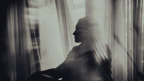 Die Konturen einer am Fenster sitzenden Frau