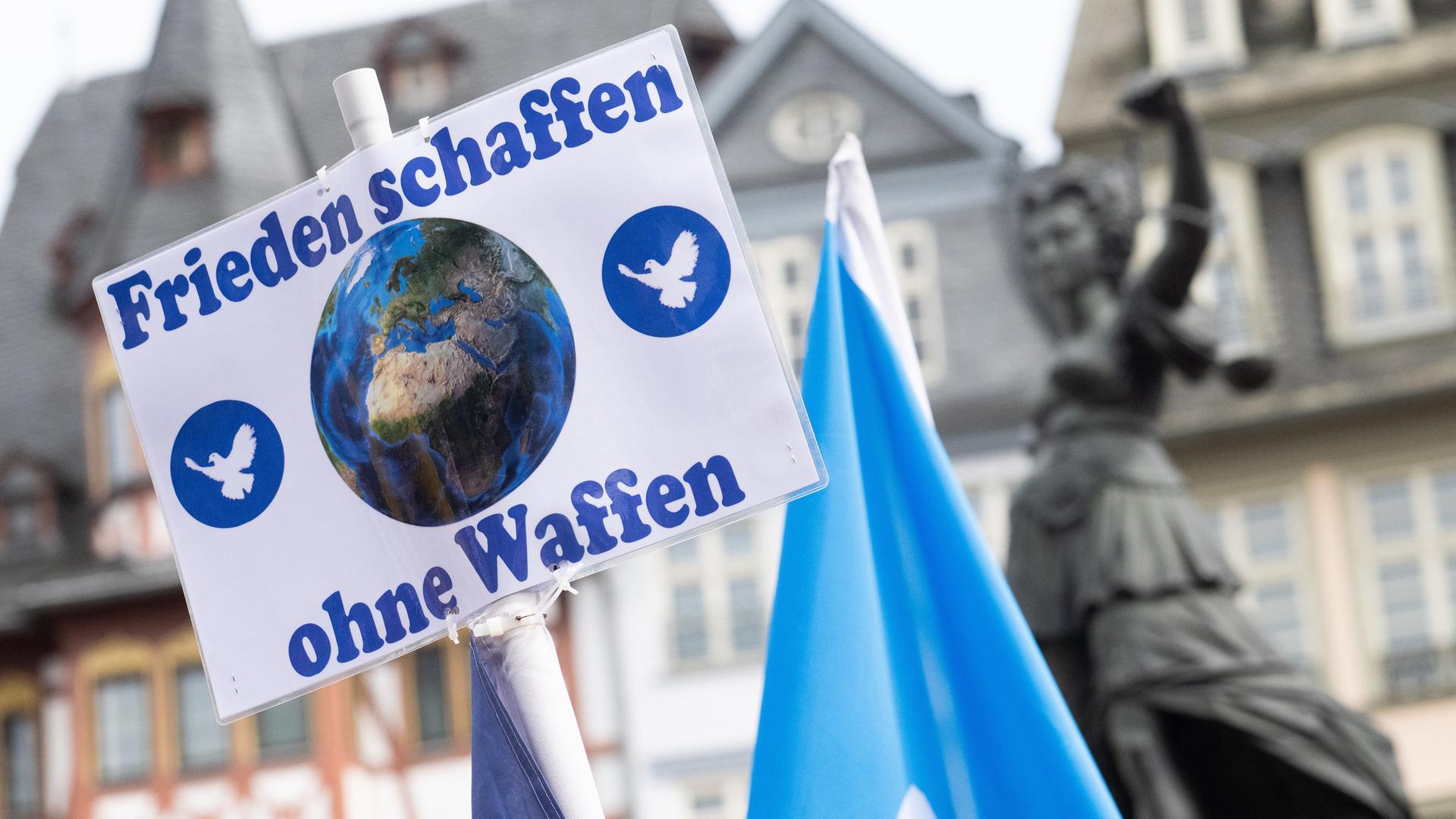 "Frieden schaffen ohne Waffen" steht auf einem Schild bei der Kundgebung zum Ostermarsch in Frankfurt. 