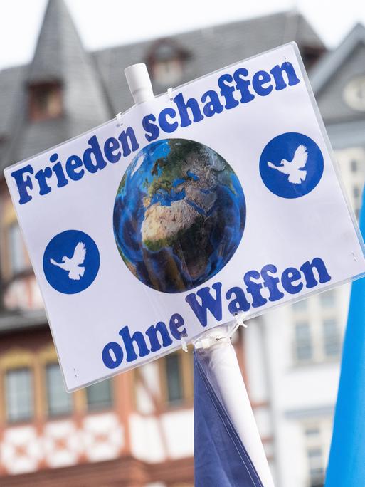 "Frieden schaffen ohne Waffen" steht auf einem Schild bei der Kundgebung zum Ostermarsch in Frankfurt. 