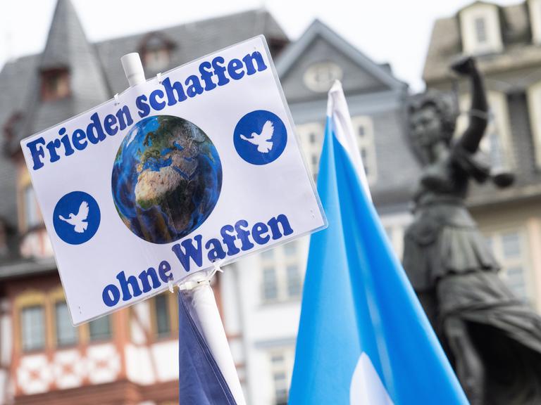 "Frieden schaffen ohne Waffen" steht auf einem Schild bei der Kundgebung zum Ostermarsch in Frankfurt. 